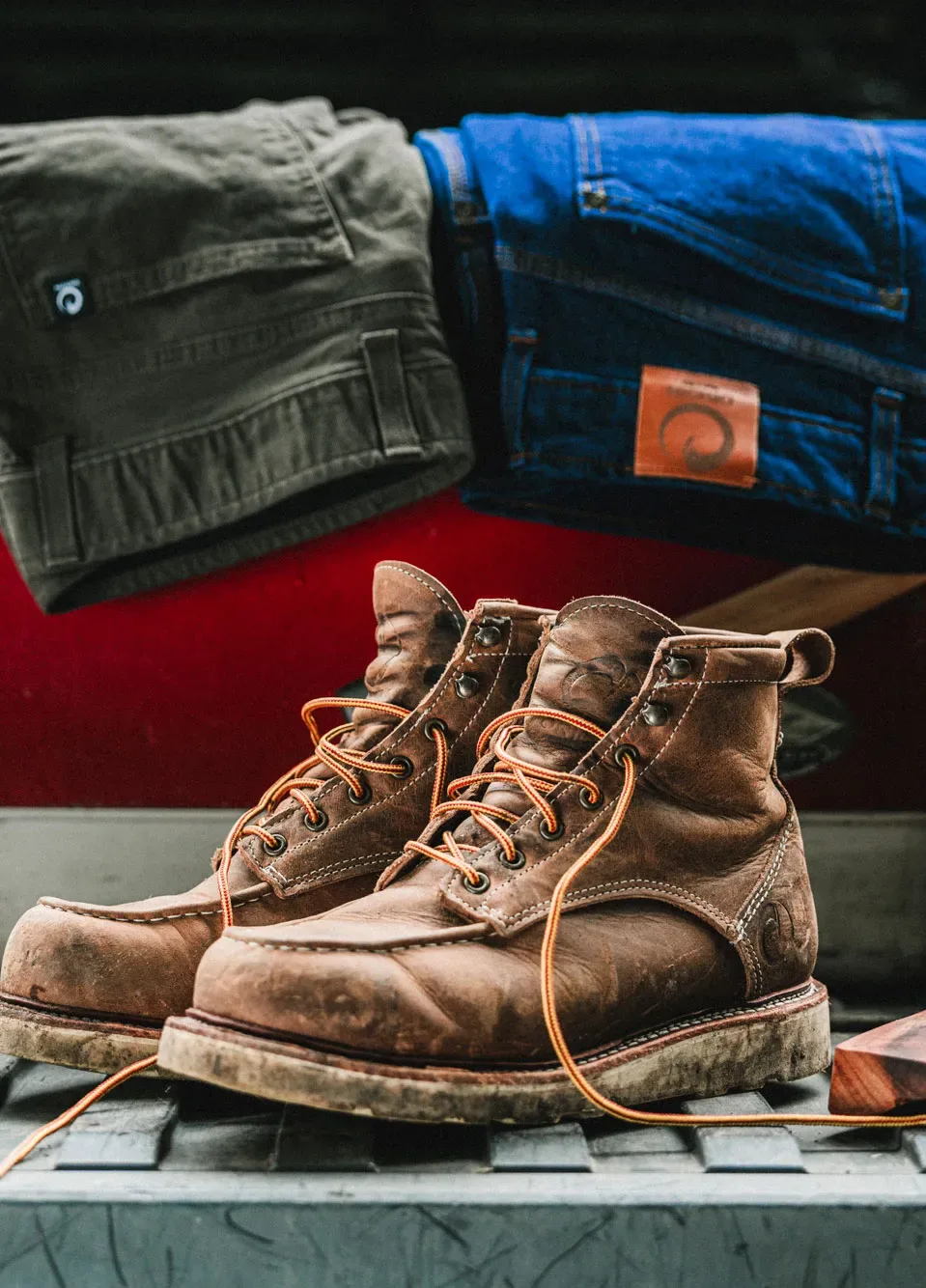 A pair of well-worn Origin work boots on a bench